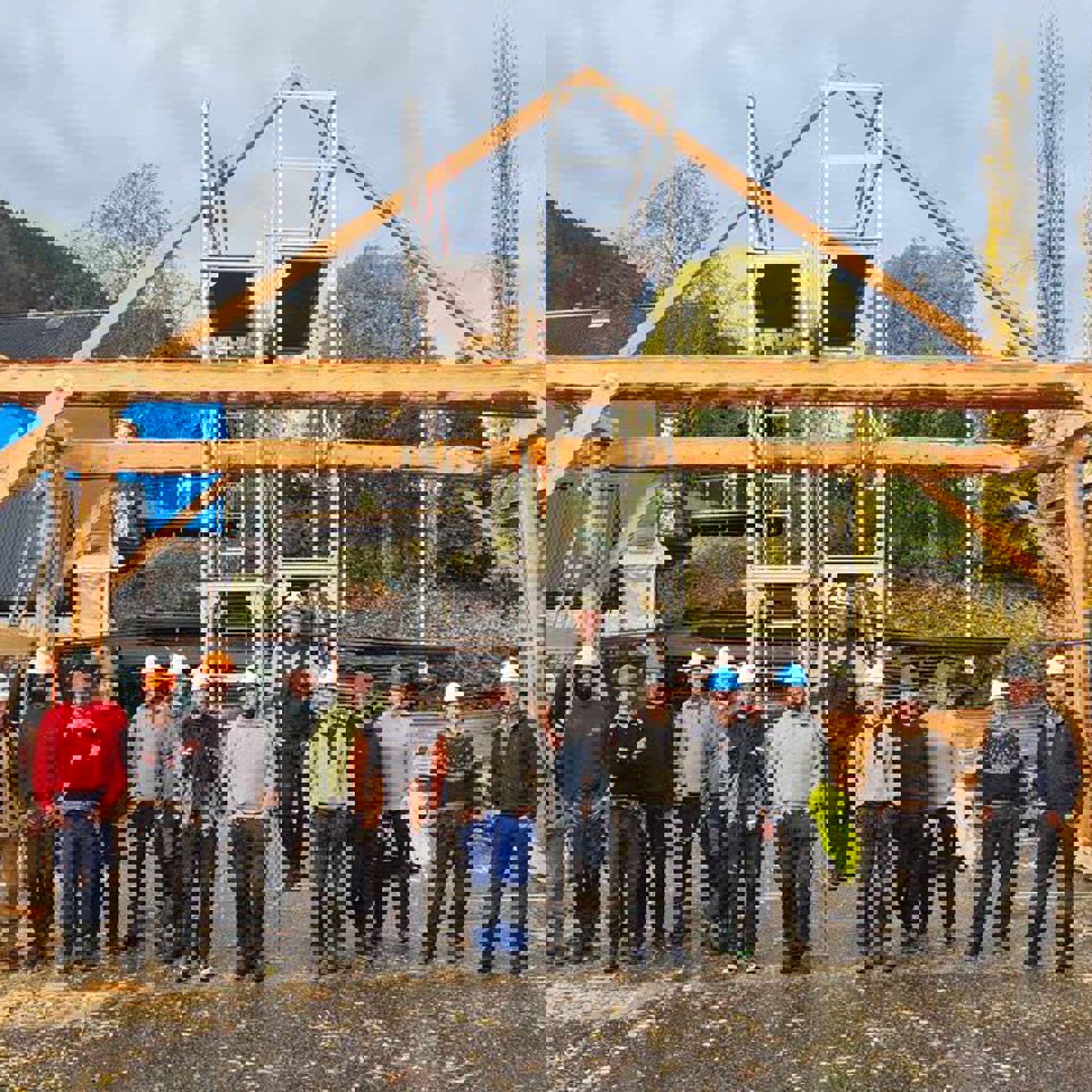 Ei gruppe studentar foran eit reisverk av tømmerstokkar
