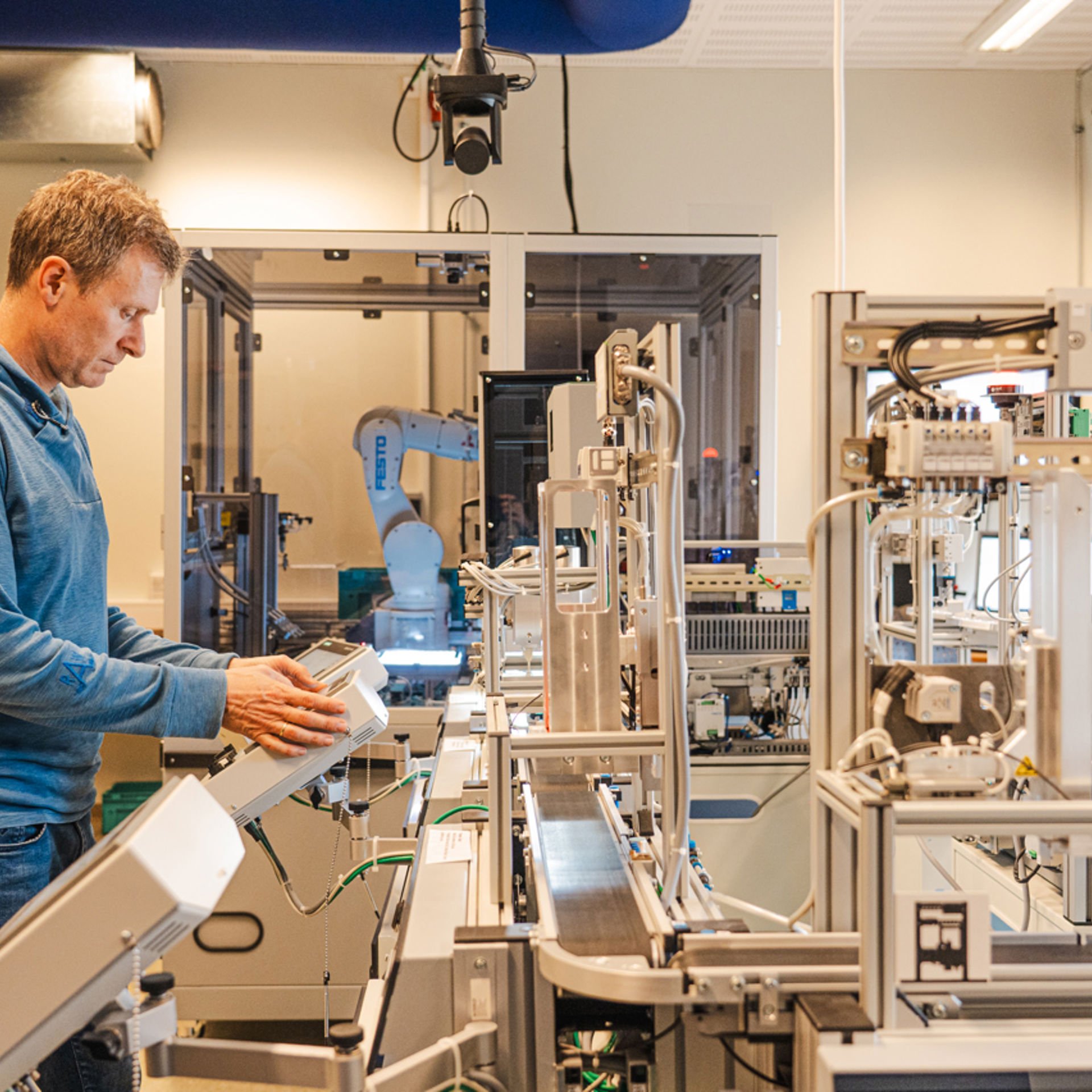 Mann som styrer eit robotsystem