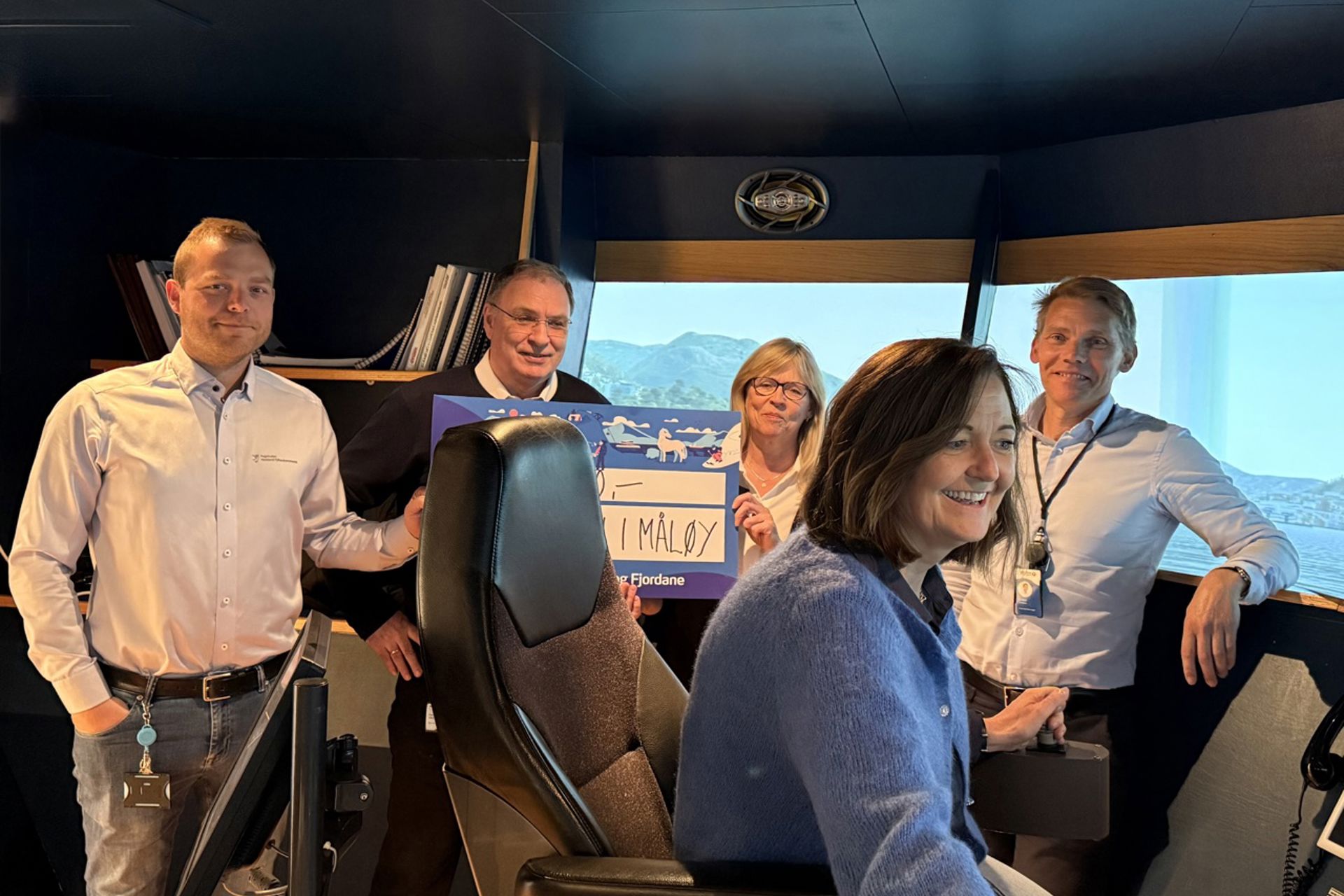 Bildet viser fleire personar som sit i ein brusimulator