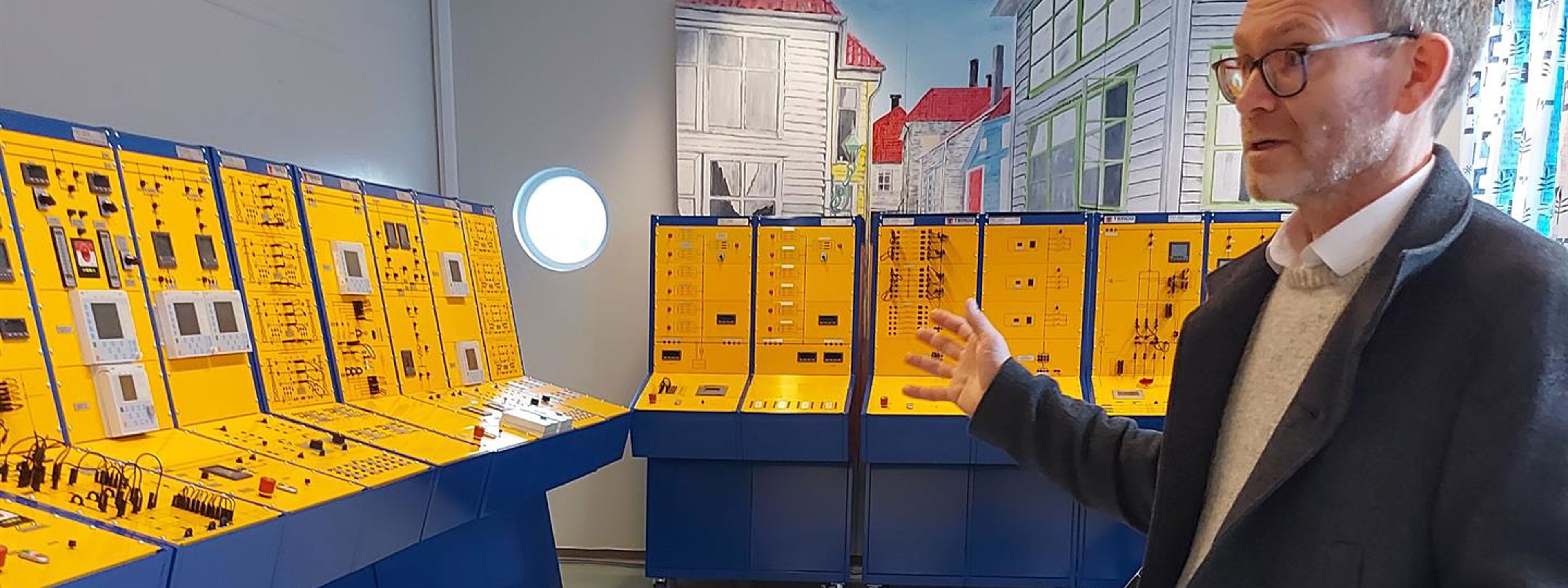Statsekretær Hoel er imponert over de moderne laboratoriene Fagskolen i Hordaland disponerer. På kraftproduksjonslaboratoriet fikk han se hvordan en simulator for elektrisk kraftproduksjon fungerer.